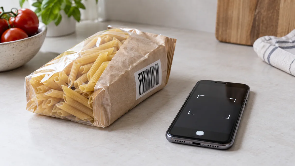 A phone beside a food package with a visible barcode
